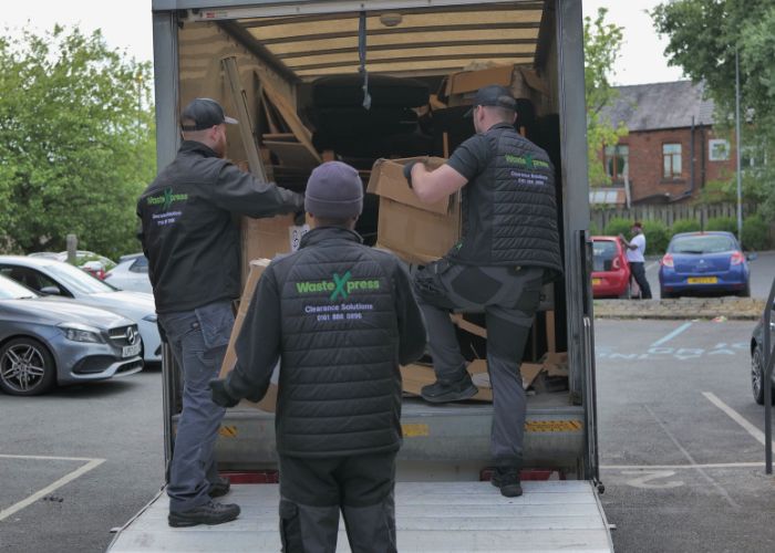 A photo of three wastexpress staff loading boxes into the van