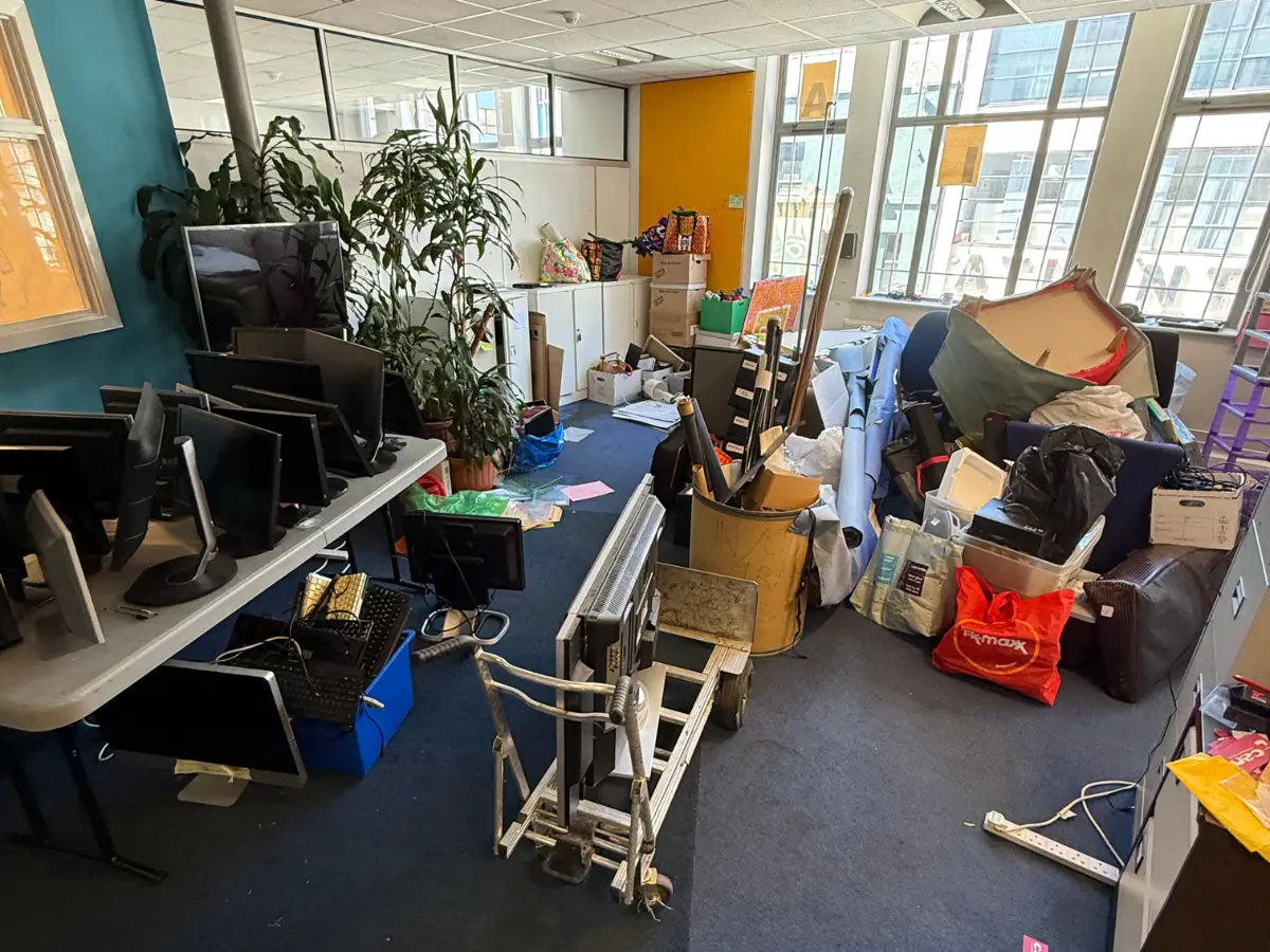 Office containing computer monitors, furniture and equipment ready for professional clearance.