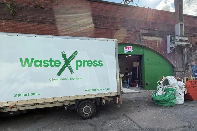 WasteXpress clearance van collecting commercial waste from a business premise in Manchester.