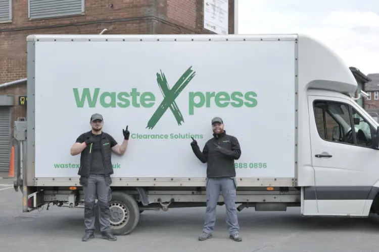 Two WasteXpress staff members standing beside a sign written clearance van used for office clearance in Manchester.