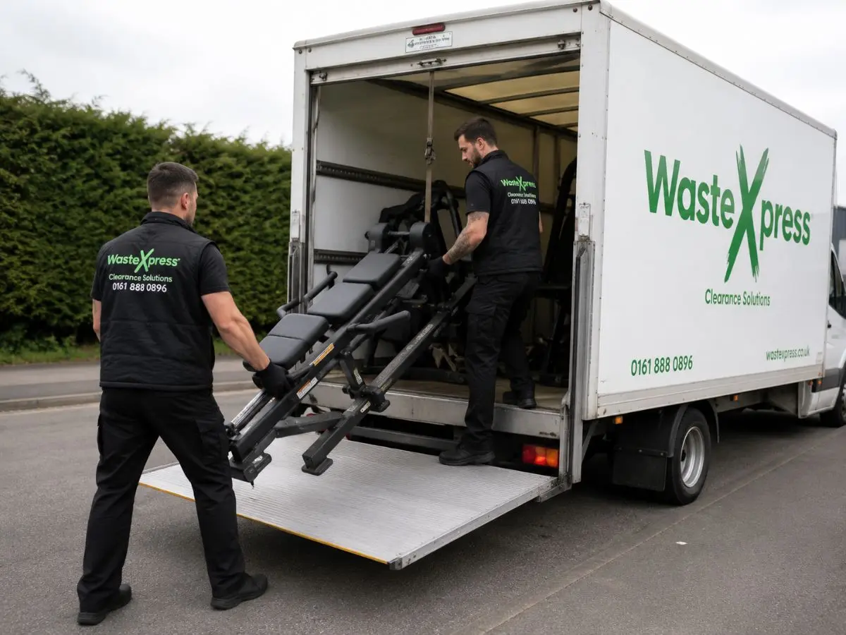 WasteXpress clearance team loading heavy gym equipment into a commercial removal van during a gym clearance project.