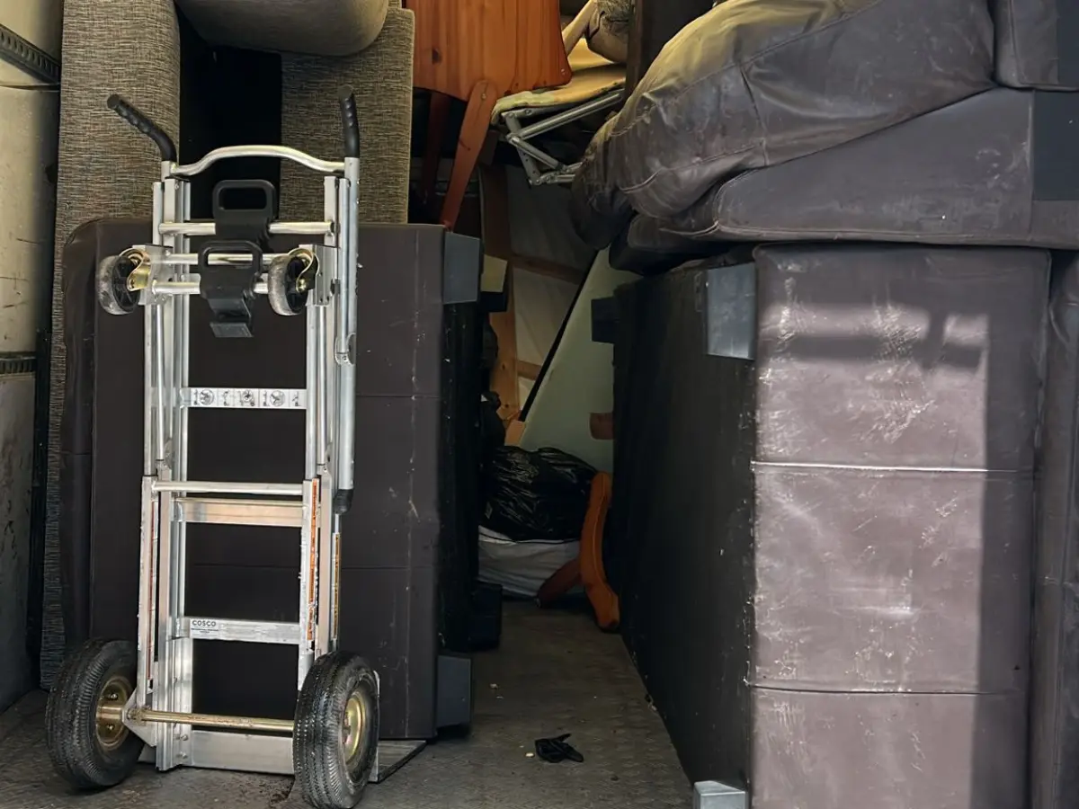 Old sofa securely loaded inside a removal van ready for responsible furniture collection, recycling, and disposal in Manchester.