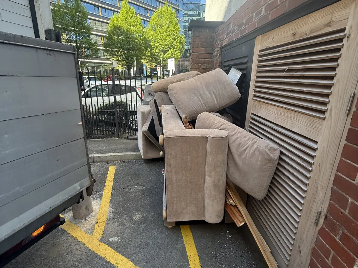 Old sofa left outside a property awaiting professional bulky waste collection and furniture removal in Manchester.