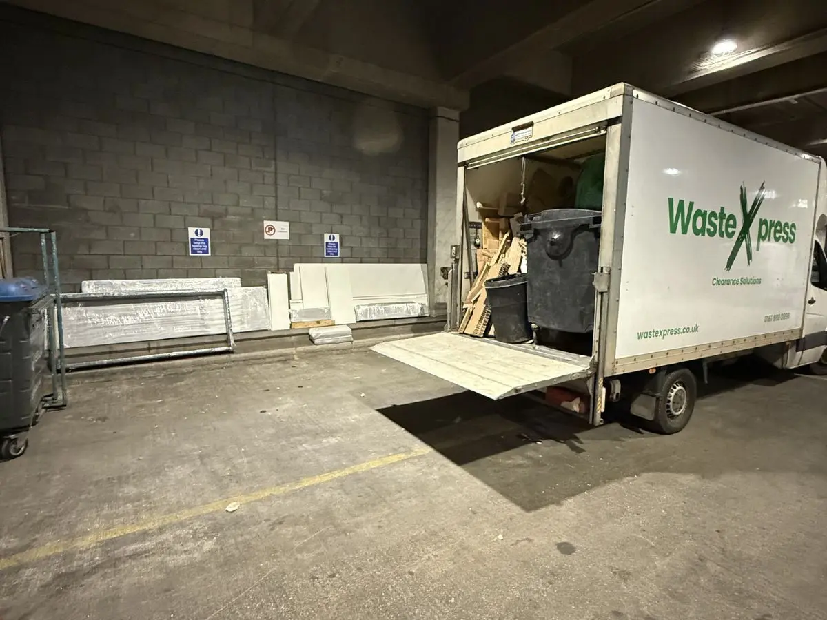 WasteXpress van parked inside a commercial loading area during bulky waste collection and clearance work.