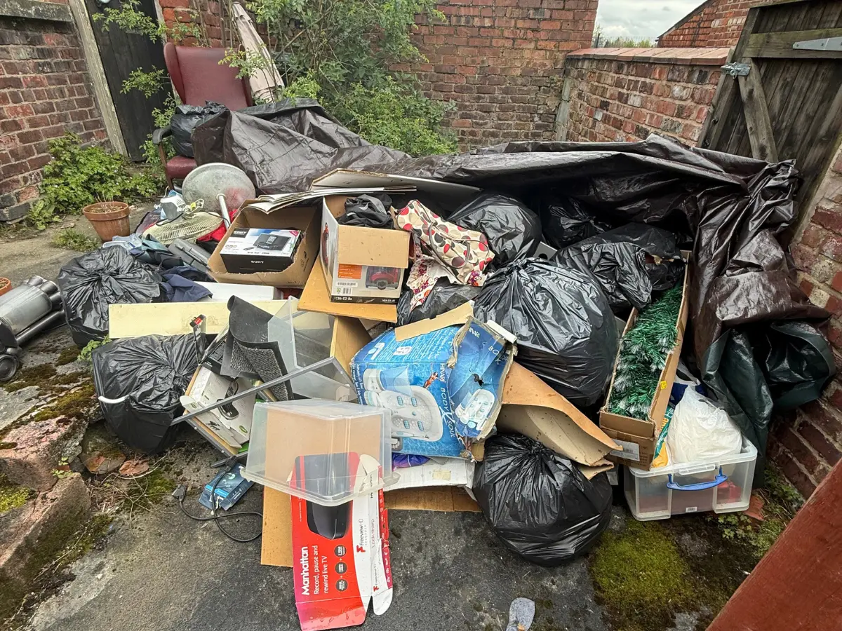 Mixed household rubbish, bags, boxes and bulky items ready for collection by a rubbish removal company in Manchester.