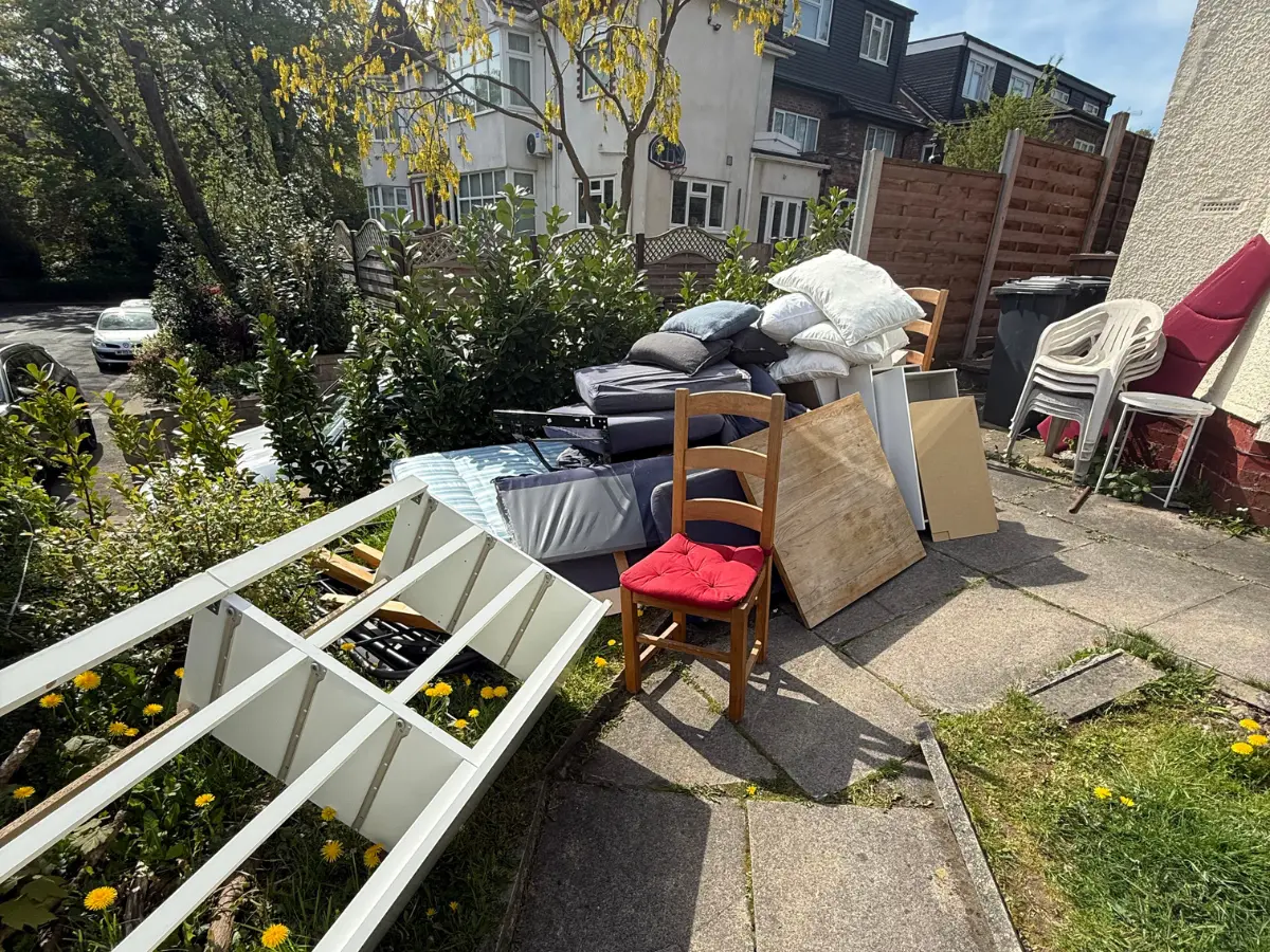 Household furniture and rubbish ready for collection by a licensed waste carrier.